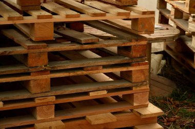 Tahta paletler bir depoda üst üste istiflenmiş.