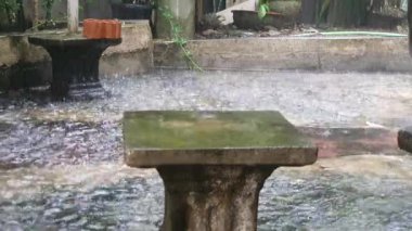 Ev bahçesinde şiddetli yağmur var. Şiddetli yağmur bahçede yağıyor.