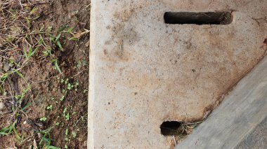 Toprak dokusu ve beton su çukuru örtüsü.