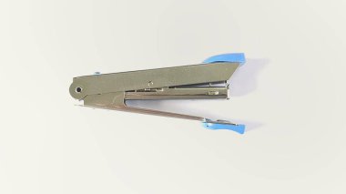 Beyaz arka planda mavi kenarı olan paslanmaz çelikten yapılmış zımbalar.