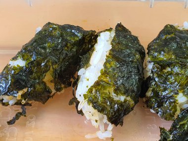 Japon yemeği Onigiri ya da Kore suşi böreği ya da Kimbap gibi yosunlara sarılmış sıcak pirinç.