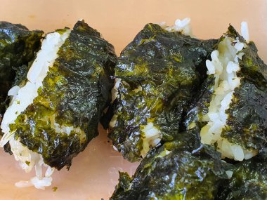 Japon yemeği Onigiri ya da Kore suşi böreği ya da Kimbap gibi yosunlara sarılmış sıcak pirinç.