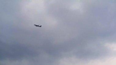 Bulutlu gökyüzünde uçan uçak. Kopya alanı olan bulutlu gökyüzü. Uçak dağların ve denizin üzerinden kalkıyor. Hava taşımacılığı ile seyahat et