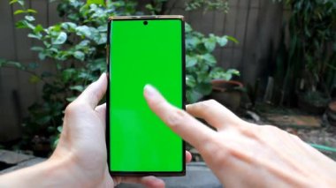Akıllı telefon ekranını yeşil ekran ile kaydırmak, arka planda bahçe ile