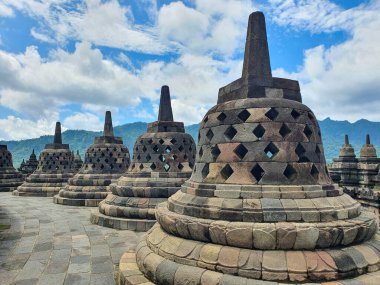 Magelang 'daki Borobudur Tapınağı' nın antik taş yapıları. Bulutlu Gökyüzü Altındaki Tarihi Tapınak Kompleksinin Mimari Mucizeleri, Entrika Taşlar ve Kültür Mirası Araştırması