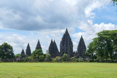 Antik Taş Prambanan Tapınakları, Yogyakarta. Parlak Mavi Gök 'e Karşı Ayakta Kalın, Bulutlu Gök Altında Görkemli Mimari Mucizeler. Tarihi Yapılar, Kültür Mirası