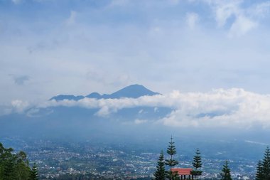 Majestic Mountain View: Doğa Sarmaşığı 'nda Yayılan Şehrin Üzerindeki Bulutlar, Huzur ve Huzur, Doğal Güzelliğin Nefes Kesen Panoraması