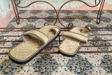 Doğal Malzemeler 'den el yapımı Sandaletler Rustik Metal Rafta, Geleneksel Teknikler ve Sürdürülebilir Tasarım, Enfes Detaylı ve Toprak Tonları' na Dayanıyor.