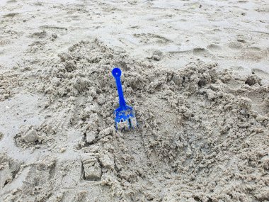 Blue Plastic Toy Toy Rake in Sand: A Child 's Playtime Fun, Summer Outdoor Actitivity, Beach Toys, Sandcastle and Creative Play. Dokuları ve Yapı Becerilerini Doğanın Sandbox 'unda Keşfediyor.