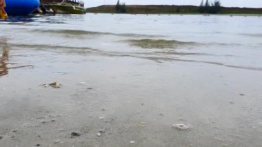 Küçük, kumsal kıyılarında yumuşak dalgalar, afişler için metin kopyalama alanı, kartlar. Deniz dalgalarının yüksek açılı görüntüsü kumda kırılıyor..