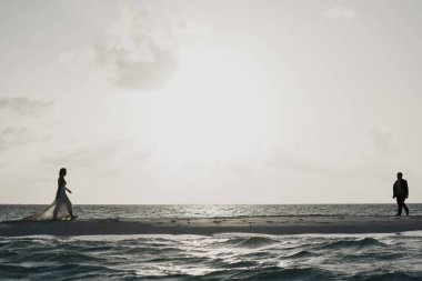 Latin eşler düğünlerini sahilde kutluyorlar.