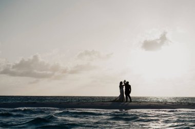 Çiftler sahilde ve denizde seansın keyfini çıkarıyorlar.