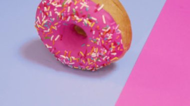 Pembe ve mavi arka planda taze pişmiş donut.