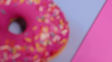 Pembe ve mavi arka planda taze pişmiş donut.
