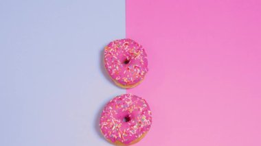 Pembe ve mavi arka planda taze pişmiş donut.