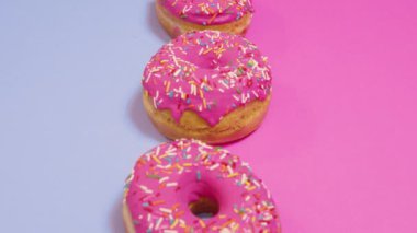 Pembe ve mavi arka planda taze pişmiş donut.