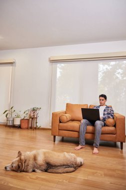 Genç adam evde çalışmaktan mutlu.