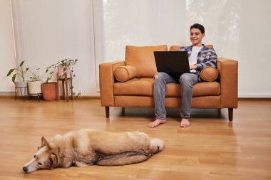 Genç adam evde çalışmaktan mutlu.