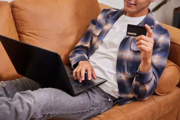 Adam kanepesinden online alışveriş yapıyor, tanınmayan biri.