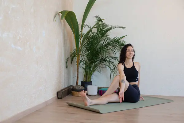 Yoga yapan genç, güzel Latin kız ısınma hareketleri ve esnemeler yapıyor.