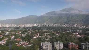 Venezuela 'nın başkenti Caracas' ın havadan görünüşü bulutlar ve mavi gökyüzüyle dolu bir sabahta