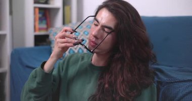 İkili olmayan kişi, mutlu bir yüzle evde dizüstü bilgisayarıyla çalışıyor.