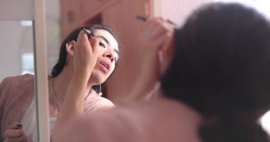 İkili olmayan kişi işe gitmeden önce yüzüne makyaj yapıyor.