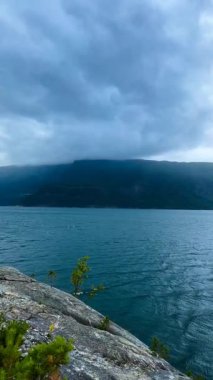 Hardangerford 'un hayalî manzarası. Dalgalı mavi su, kayalık sahil. Arka plan gökyüzü bulutu. En kaliteli fotoğraf Yüksek kaliteli FullHD görüntüler