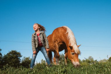 Atla gülümseyen küçük kız.