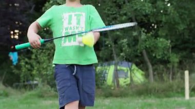 Küçük bir çocuk badminton oynamayı öğreniyor. Her yaş için spor konsepti. Çocuklar için anaokulu sporları, açık hava aktiviteleri