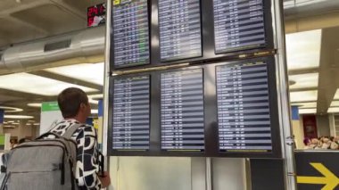 Palma de Mallorca Havaalanı, PMI, 18 Eylül 2024. Genç bir adam kalkış tahtasındaki uçuşuna bakıyor.