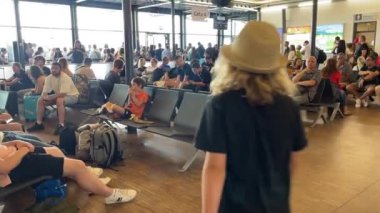 Memmingen. Memmingen Havaalanı, Almanya 25.06.2024. Kapıda farklı yaşlarda insanlar binmek için bekliyor.