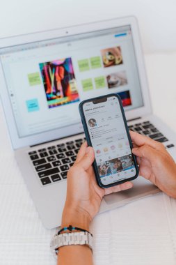 Bir çift el bilgisayarla akıllı telefon arasında ustalıkla geziniyor ve teknolojinin günlük hayatımıza kusursuz bir şekilde entegre olduğunu gösteriyor.