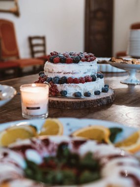 Mum yakmak ve parti için ahşap masada taze böğürtlenlerle süslenmiş ev yapımı pasta. Doğum günü partisi kutlaması