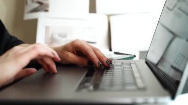 Parlak bir ofis ortamında dizüstü bilgisayarın klavyesine yazı yazan birinin eline yakın çekim. Bilgisayarda verimli çalıştıklarında parmaklar üzerinde yoğunlaşarak, verimliliği aktarırlar.