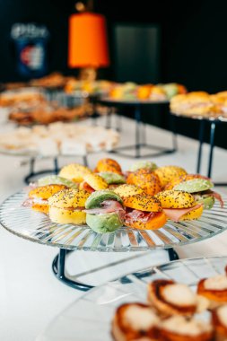 Renkli çöreklerle çeşitli gurme sandviçler zarif cam tepsilerde ustalıkla düzenlenir. Yemek servisi, resepsiyonlar ve özel durumlar için mükemmel..