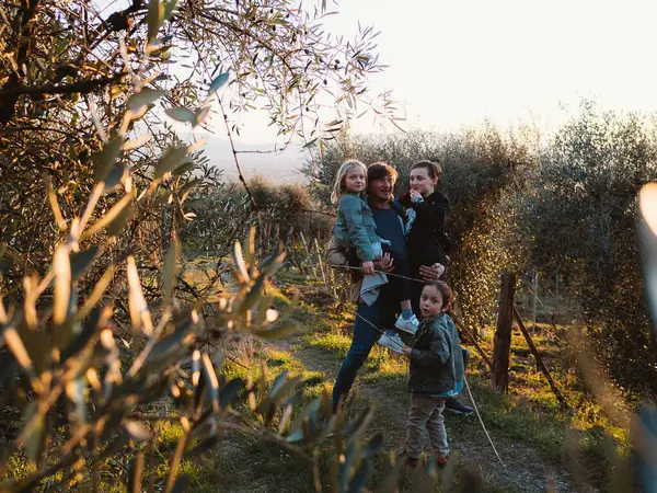 Baba ve üç çocuğu, bir bahçe ve tarlada ağaçlarla çevrili doğal bir ortama daldılar. Eğlence ve aile paylaşımı anı