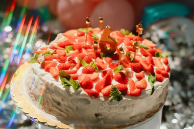 Üstü taze çilek ve nane yapraklarıyla kaplanmış kutlama pastası, altı numaralı mum, altıncı yaş günü partisi ya da yıldönümü için mükemmel. Canlı bir şenlik havası yakalar.