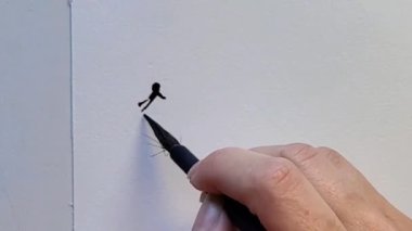 Beyaz kağıda çizilen mürekkebin ilk darbelerini yaratmak için fırça kullanan bir elin yakın çekimi. Sanatsal çizimin hassasiyeti ve tekniği üzerinde duruluyor..