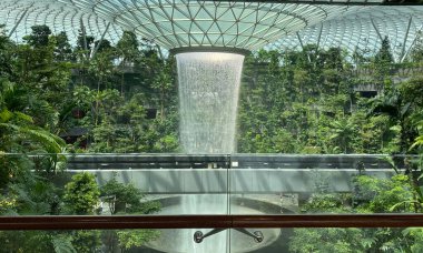 Çimenlik ve cam kubbeyle çevrili kapalı bir şelale..