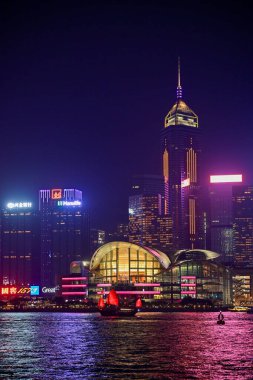 Night view of skyscrapers with colourful lights reflecting on the water at Victoria Harbour. This photo was taken in Tsim Sha Tsui, Hong Kong on November 26, 2023.