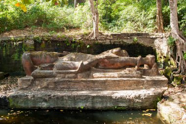 shesha shayana, sleeping vishnu sculpture inside bhandavgarh tiger reserve during a wildlife safari on a hot summer day clipart