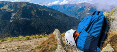 Seyahat için sırt çantası, dağlara tırmanmak için kask. Dağlarda geziyorum. High Tatras 'ta yürüyüş. Bir yaşam tarzı olarak dağlarda yürüyüş yapmak. Dağ tırmanma ekipmanı. Dağ yolunda dur.