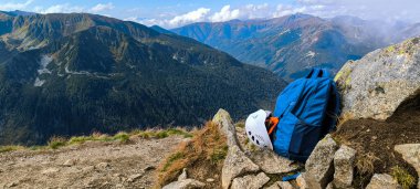 Seyahat için sırt çantası, dağlara tırmanmak için kask. Dağlarda geziyorum. High Tatras 'ta yürüyüş. Bir yaşam tarzı olarak dağlarda yürüyüş yapmak. Dağ tırmanma ekipmanı. Dağ yolunda dur. Dikey fotoğraf