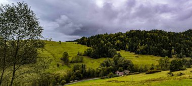 Fırtına havasında tepelerin arasında uzanan bir dağ köyü. Kırsal dağ manzarası. Dağları aşın
