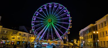 Bialystok, Polonya 22.10.2024: Akşam ışıklarıyla eski şehrin meydanında dönme dolap. Eski Bialystok kasabasının merkezi. Eski kasabadaki binalar ve restoranlar.