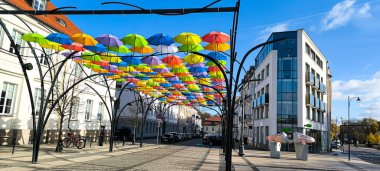 Bialystok, Polonya - 23.10.2024: Çok sayıda parlak renkli yağmur şemsiyesi kurulumu. Bialystok 'un turistik bölgelerinde yürüyor.