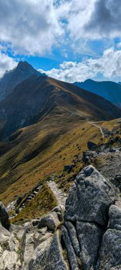 Favori bir hobi olarak dağlarda yürüyüş yapmak. Aktif yaşam tarzı. Yürüyüş patikalarından Tatra Dağları ve Yüksek Tatralar 'ın manzarası. Dağlar arasındaki dağ tepeleri, yamaçlar ve vadiler. Dikey fotoğraf