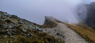 Tatra 'da yürüyüş. Batı Tatra 'da, High Tatras' ta dağ yamaçları, zirveler ve yürüyüş yolları. Dağlar bulutlarla kaplı.