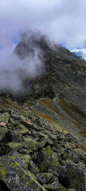 Hiking in the Tatras. Mountain slopes, peaks and hiking trails in the Western Tatras, in the High Tatras. Mountains covered with clouds. Swinica Mount and Swinica Pass in the clouds.  clipart